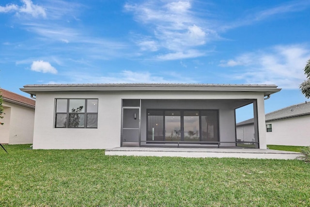 rear view of property featuring a lawn and a sunroom