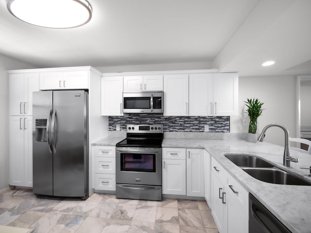 kitchen featuring sink, light stone counters, white cabinets, and stainless steel appliances