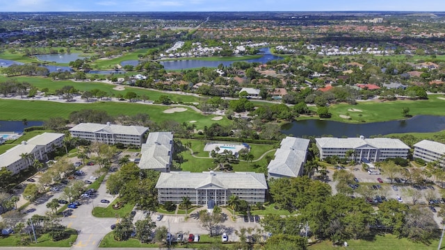 drone / aerial view with view of golf course and a water view