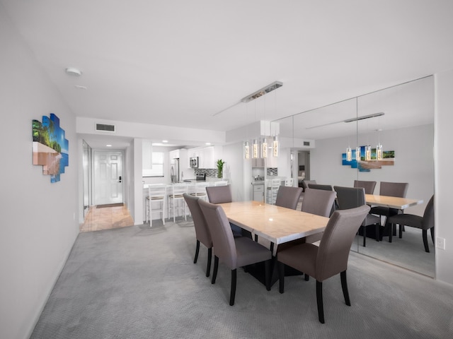 dining area with light colored carpet