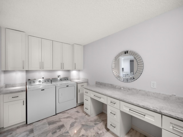 washroom featuring cabinet space, a textured ceiling, marble finish floor, and washer and dryer