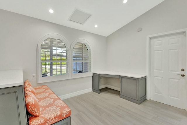 home office with light hardwood / wood-style floors and lofted ceiling