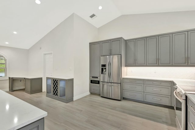 kitchen with gray cabinets, light hardwood / wood-style floors, and appliances with stainless steel finishes