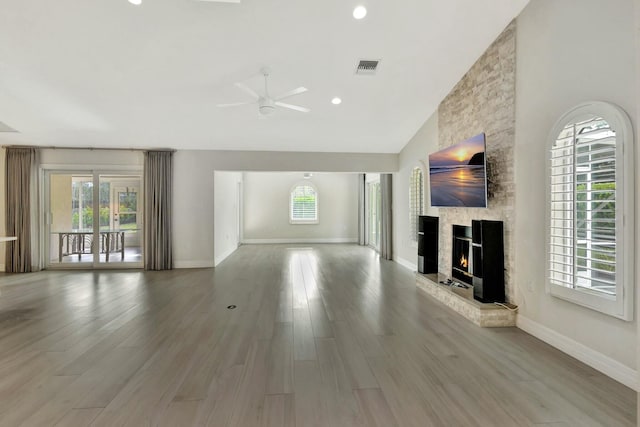 unfurnished living room with a fireplace, hardwood / wood-style floors, vaulted ceiling, and ceiling fan