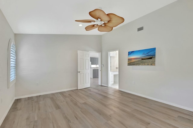 empty room featuring ceiling fan, light hardwood / wood-style floors, and vaulted ceiling