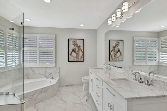 bathroom featuring tiled bath, vanity, and toilet