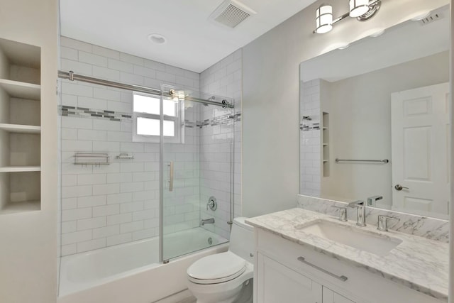 full bathroom featuring shower / bath combination with glass door, vanity, and toilet