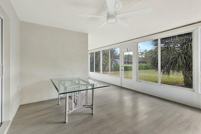 unfurnished sunroom featuring ceiling fan