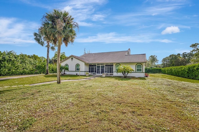 view of front of house featuring a sunroom and a front yard