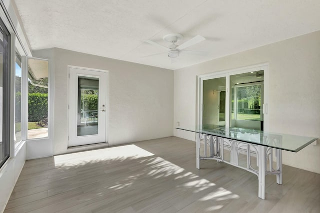 unfurnished sunroom featuring ceiling fan