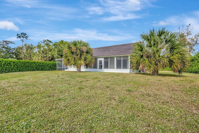 back of property featuring a sunroom and a yard