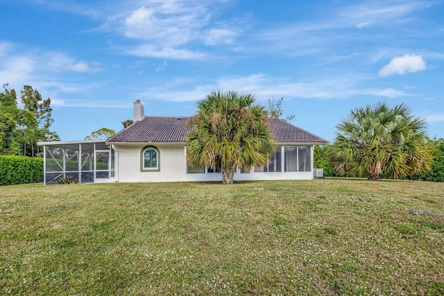 rear view of property with a sunroom and a lawn