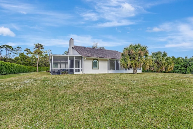 back of house featuring a yard and a sunroom