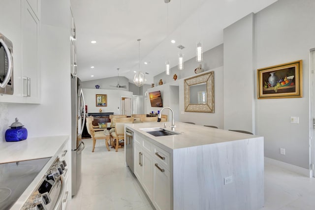 kitchen with pendant lighting, lofted ceiling, a center island with sink, sink, and white cabinetry