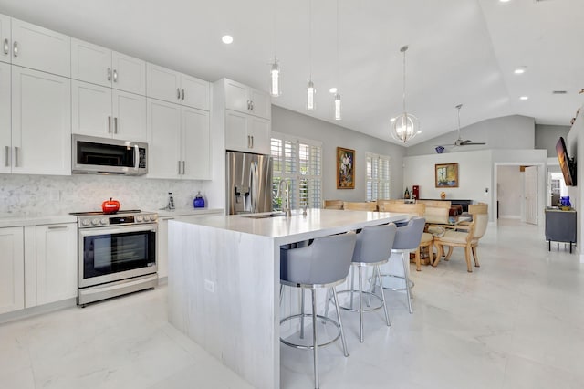 kitchen with white cabinets, stainless steel appliances, and lofted ceiling