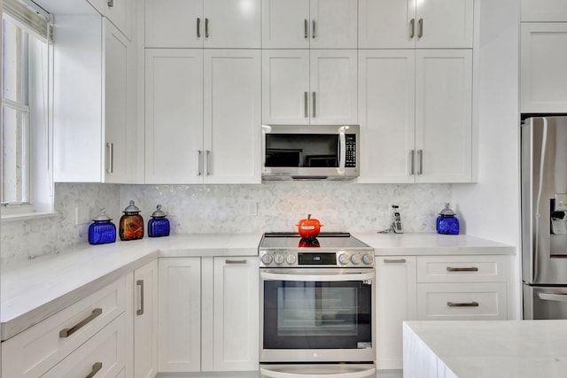 kitchen featuring backsplash, white cabinetry, and stainless steel appliances