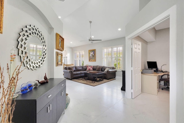 living room featuring ceiling fan and built in desk