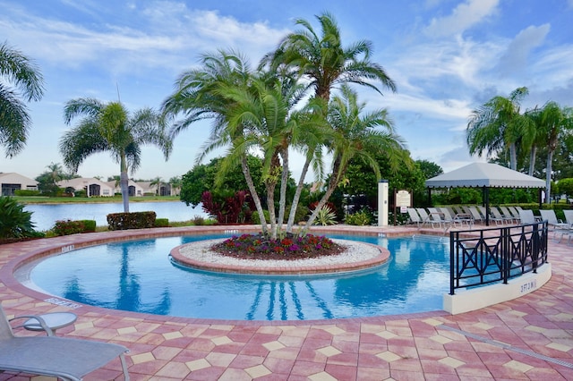 view of pool with a water view and a patio area