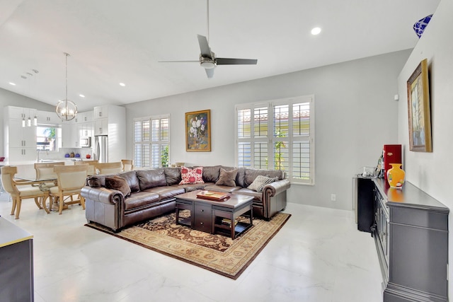 living room with ceiling fan with notable chandelier, a wealth of natural light, and lofted ceiling