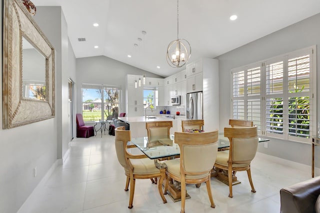 dining area with light tile patterned flooring, lofted ceiling, sink, and a chandelier