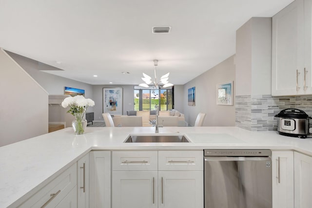 kitchen featuring sink, tasteful backsplash, stainless steel dishwasher, a notable chandelier, and white cabinets