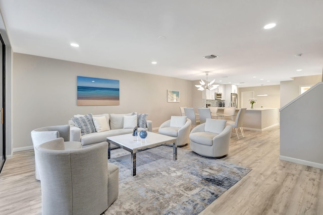 living room featuring a chandelier and light hardwood / wood-style flooring