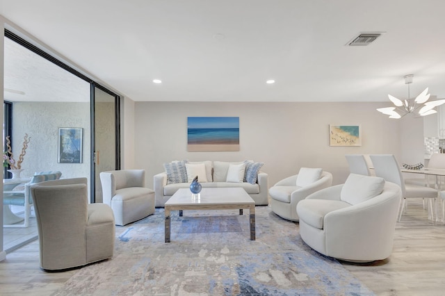 living room with light hardwood / wood-style flooring and a chandelier