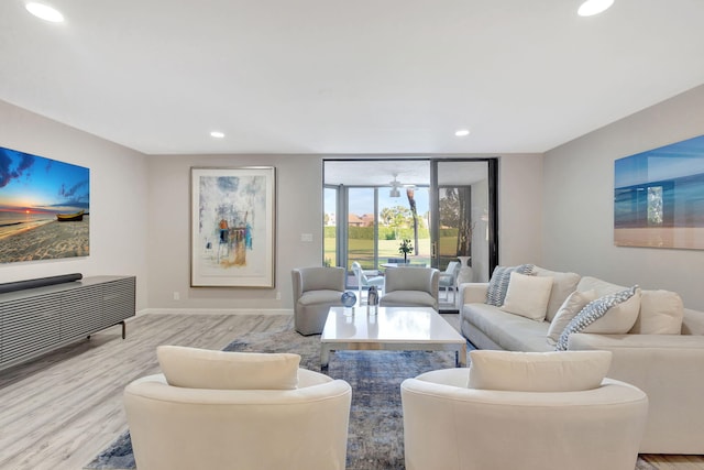 living room with light wood-type flooring and ceiling fan