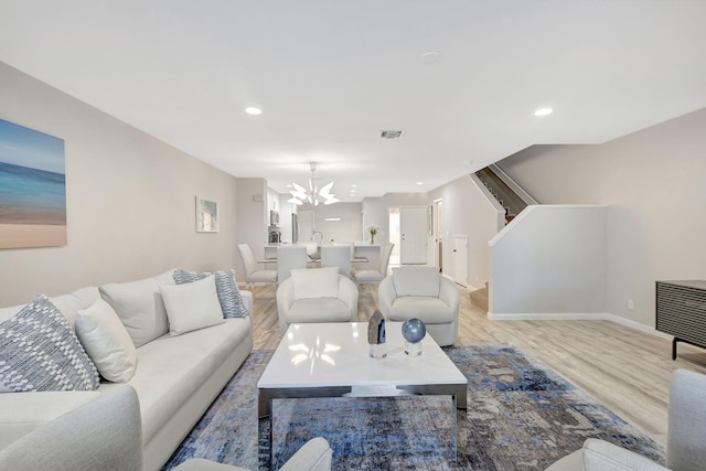 living room featuring light hardwood / wood-style flooring and an inviting chandelier