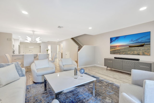 living room with a notable chandelier and light wood-type flooring