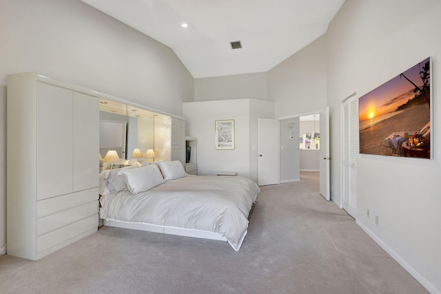 bedroom featuring light carpet and high vaulted ceiling