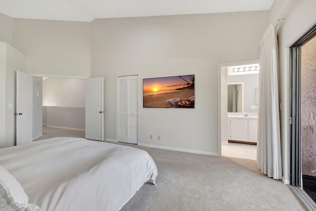 carpeted bedroom with connected bathroom, a closet, and high vaulted ceiling