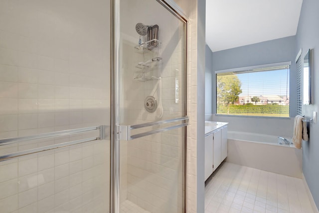 bathroom featuring tile patterned flooring, vanity, and shower with separate bathtub