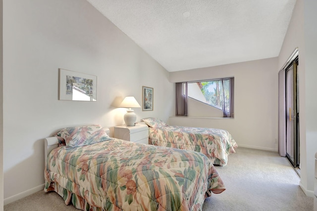 bedroom with a textured ceiling, light carpet, and lofted ceiling