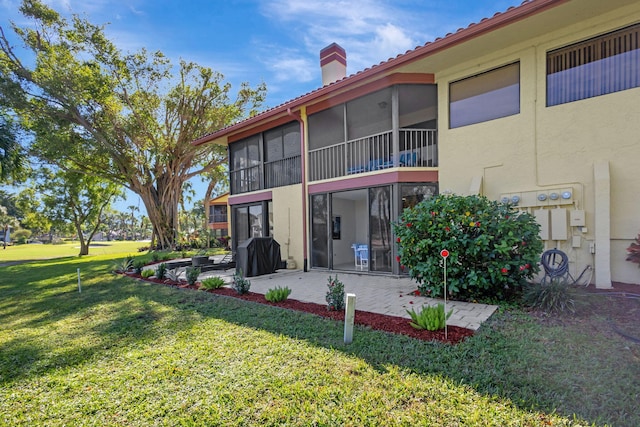 back of house with a yard and a patio