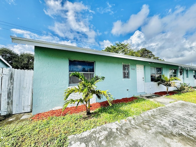 single story home featuring a front lawn