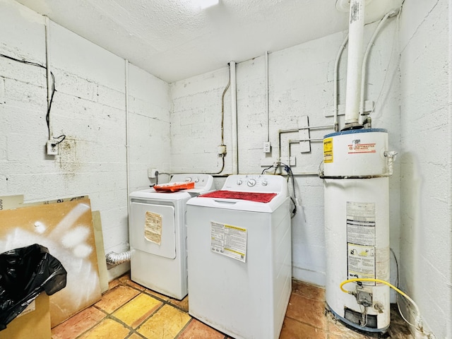 clothes washing area featuring laundry area, water heater, and washing machine and clothes dryer