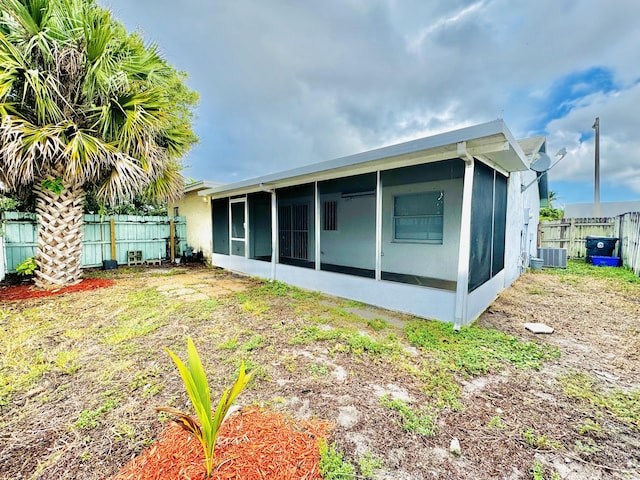 back of house with a sunroom and central AC