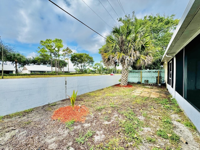 view of yard with fence and a sunroom