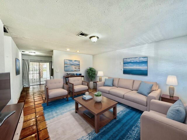 living room with tile patterned floors and a textured ceiling