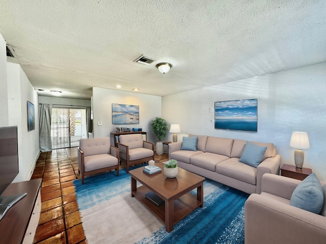 living room featuring a textured ceiling and visible vents