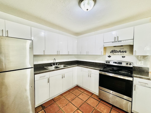 kitchen featuring a textured ceiling, stainless steel appliances, sink, light tile patterned floors, and white cabinets