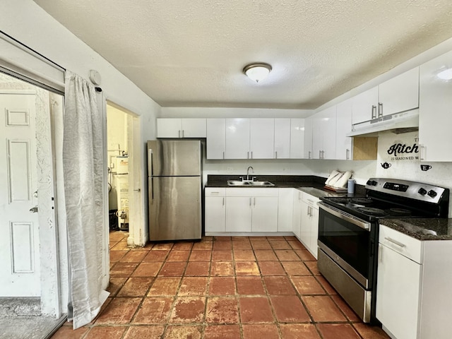 kitchen with dark countertops, appliances with stainless steel finishes, white cabinets, a sink, and under cabinet range hood