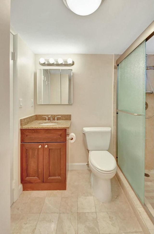 bathroom featuring vanity, toilet, and an enclosed shower