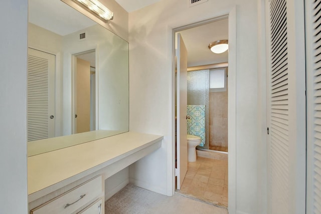 bathroom with toilet and an enclosed shower