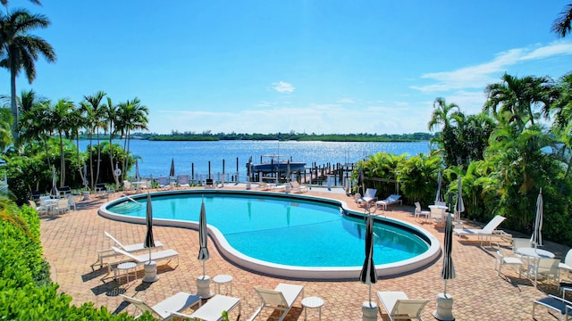 view of pool featuring a patio and a water view