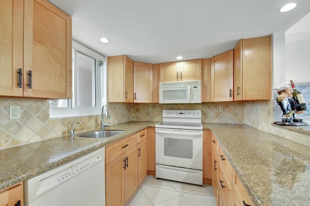 kitchen featuring white appliances, light brown cabinets, sink, light tile patterned flooring, and light stone counters