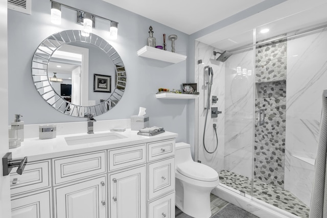 bathroom with toilet, vanity, and walk in shower