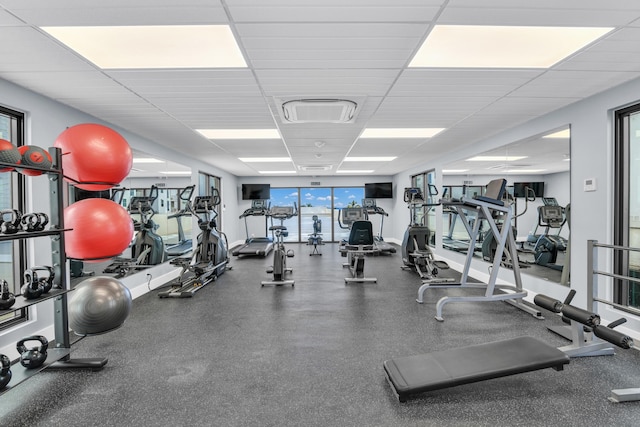 exercise room with a drop ceiling and plenty of natural light