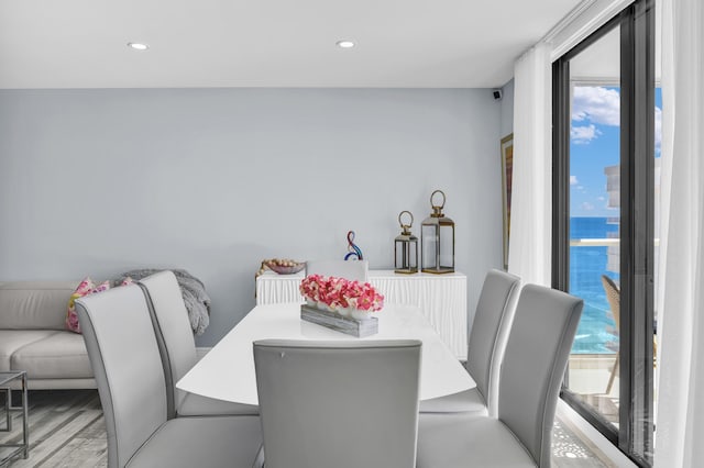 dining area with a water view and light hardwood / wood-style flooring